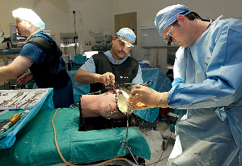 Daniel Alvarado, center, a surgical tech at the University of Texas Medical Branch, assists Dr. David Paulson, a neurosurgery resident, as they remove a blood clot on a physical simulator in an operating room at John Sealy Hospital in Galveston. The lifelike physical simulators are designed to feel and react as realistic as possible