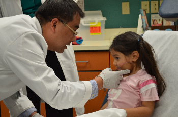 UTMB’s Dr. Andrew Zhang examines Adrianna De La Cruz, the 4-year-old who was recently bitten by dog and required microsurgery to repair her