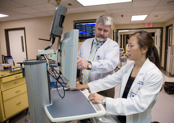 Chuck Machner, medical intensive care unit/critical care unit nursing manager at UTMB, and Shawn Nishi, M.D., assistant professor in the division of pulmonary critical care and sleep medicine, look at data in the MICU at John Sealy Hospital. Nishi and Machner were instrumental in UTMB’s efforts to reduce sepsis mortality, along with Gulshan Sharma, M.D., UTMB’s ICU director.