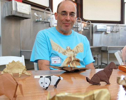 Dr. Ronald Levy sits next to his origami creations