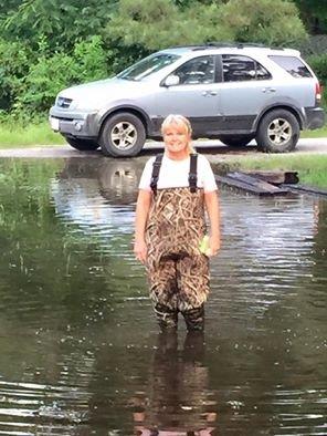 CMC employee Shelia Curry-Ware stands outside her flooded Riverside home