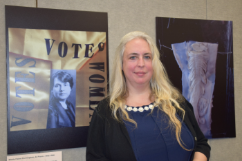Paula Summerly, Ph.D., in front of "Weaving the Stories of Women's Lives @UTMB" exhibit