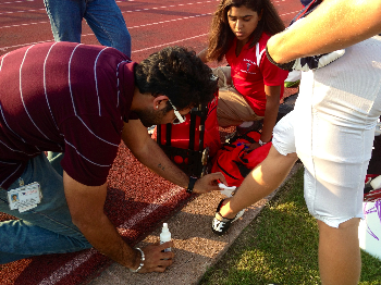 Dr. Omkar Dave  treats a football player during the game.