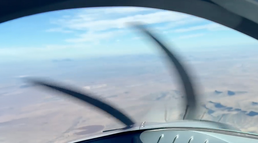 Closeup of aircraft cockpit in flight with view of outside.