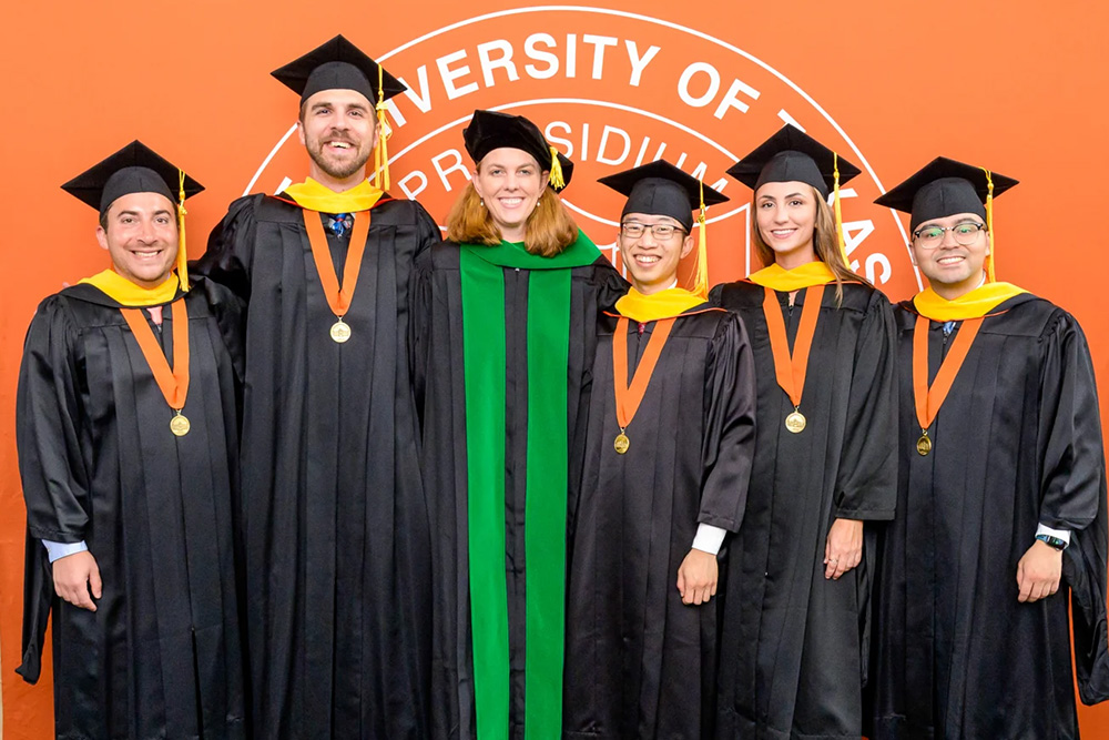 Group of male and female college graduates wearing caps and gowns.