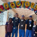 Group of doctors standing under balloon arch