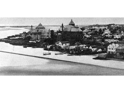 Historic aerial view of the UTMB campus and surrounding neighborhood along the Galveston waterfront.