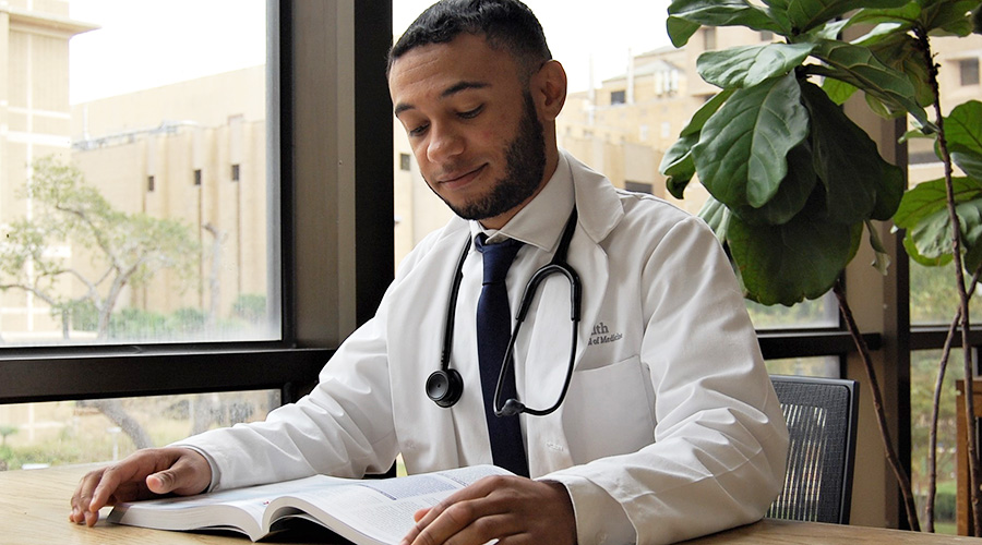 Dr. Kamerson Wells in a whitecoat reading a book