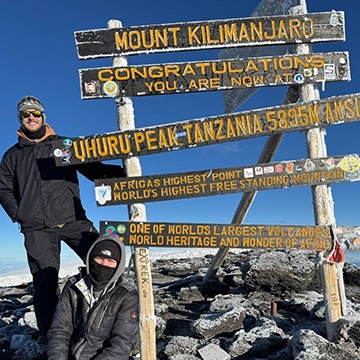 KENYA Christian Frey at Mount Kilimanjaro Two people posing at the top of Mount Kilimanjaro
