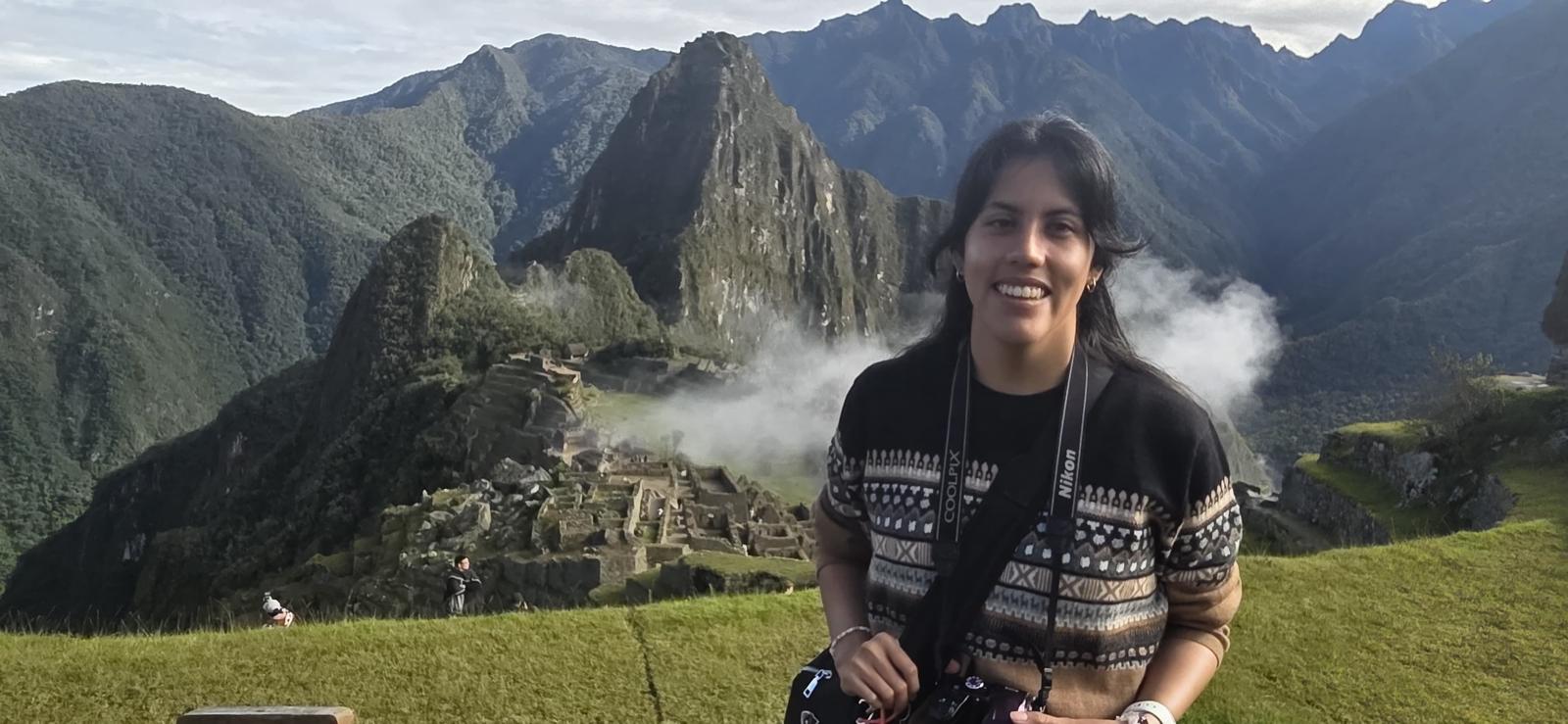 female student posing for a picture in front of the archeological site Machu Pichu