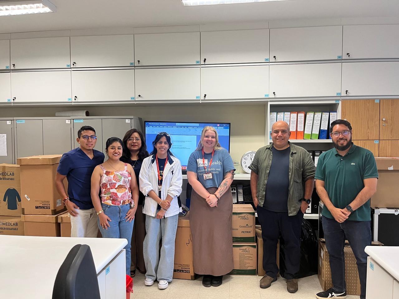group of students and faculty posing for a photo in a lab 