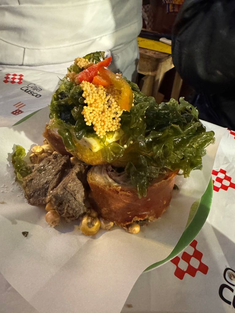 Fowler_2 A plate Peruvian cuisine containing meat, greens, red and yellow pepper, and quinoa with some corn on the side.