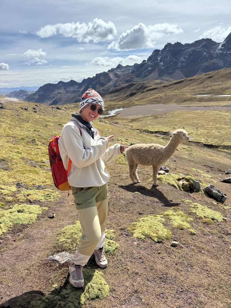 Fowler_5 Student smiling and posing with an alpaca in the mountains near Cusco, Peru