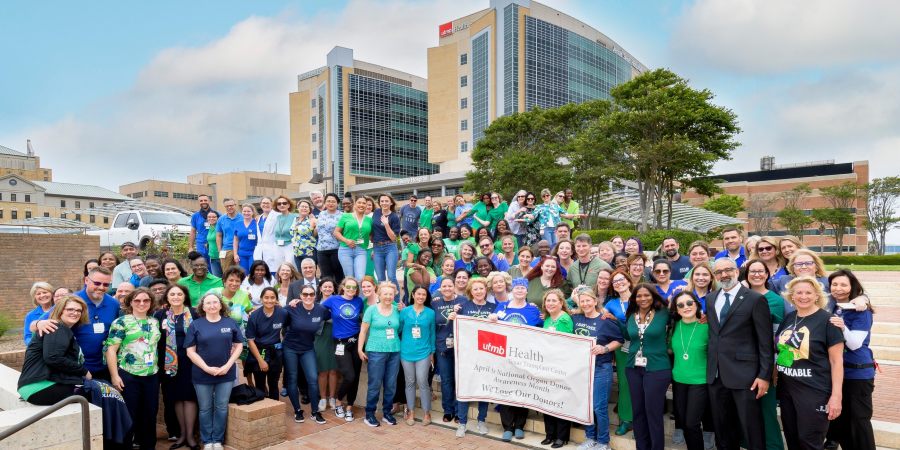Large group photo of people in blue and green