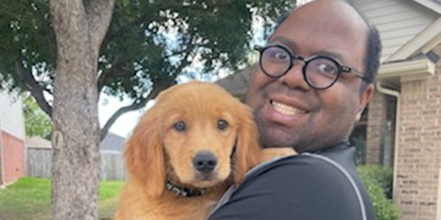 Photo of man with glasses and puppy