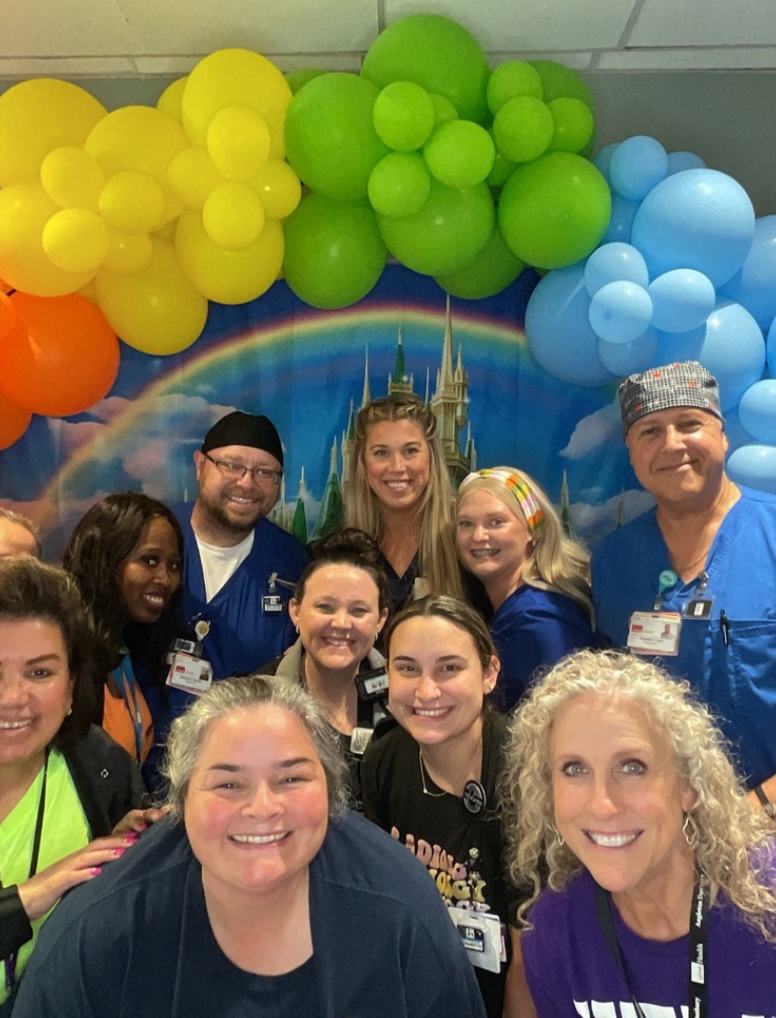 Group shot of people in front of rainbow banner