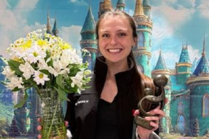 Nurse holding flowers and award