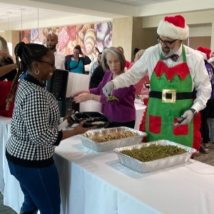 Image of man in Santa suit dishing out food