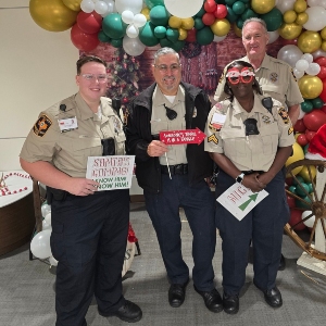 Image of three men in front of holiday decor