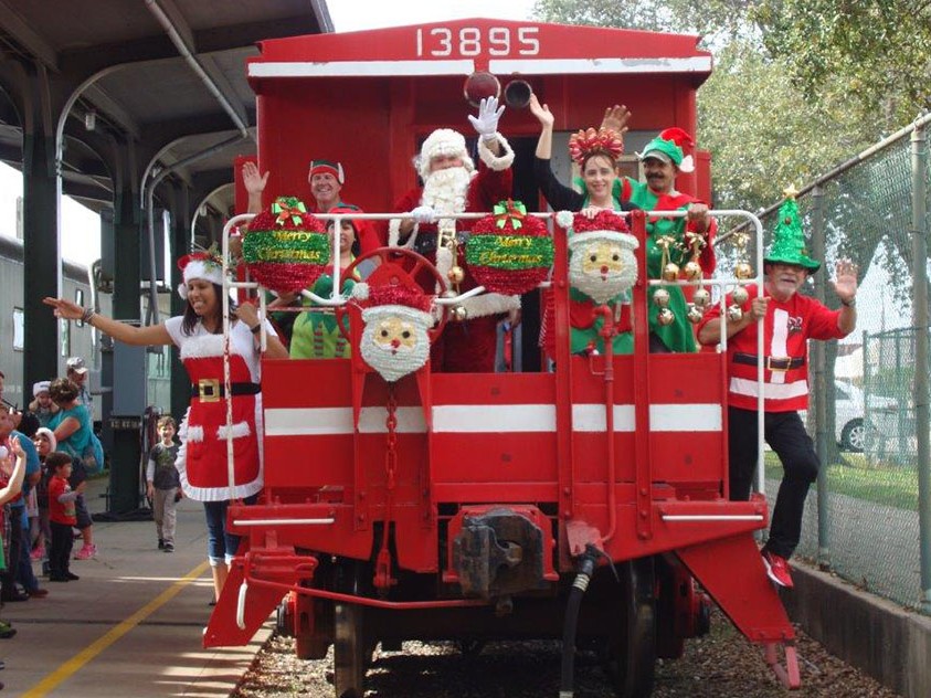 Folks in seasonal costumes arriving by festive train