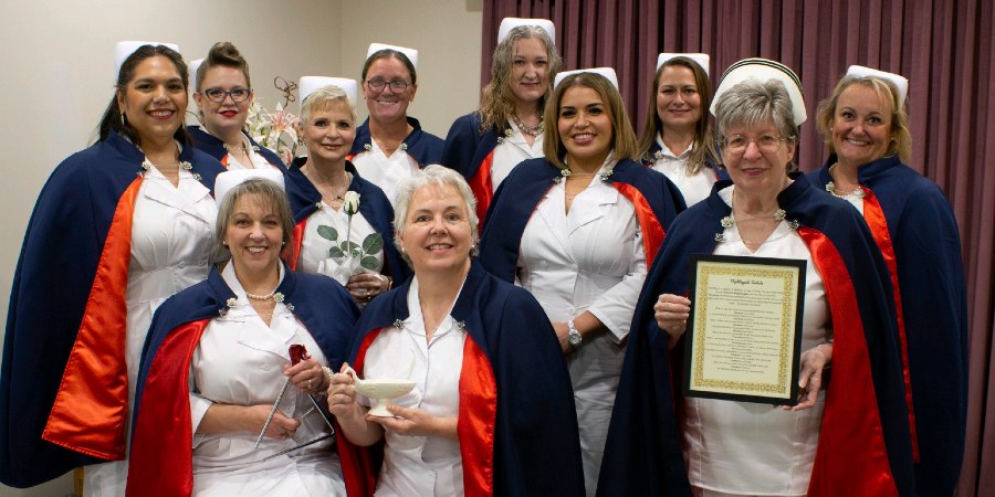 Group photo of women in nursing uniforms with capes