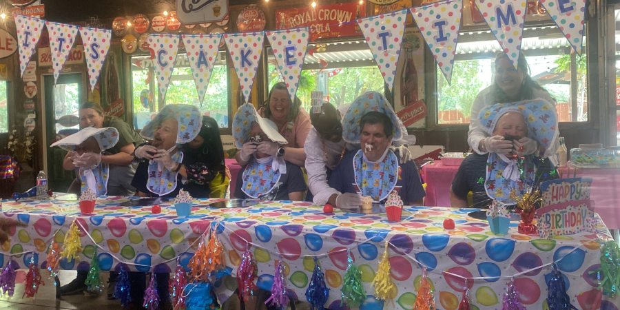 Photo of people getting cake smashed in their faces, dressed as babies