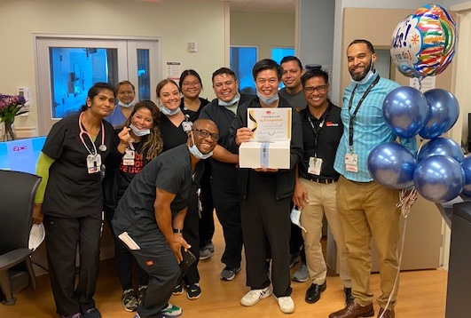 Leo Feliciano is surrounded by happy co-workers as he celebrates his honor from The Houston Chronicle
