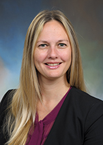 Professional headshot of Dr. Erin McGoff. Light complected woman with long, blonde hair, a burgundy shirt and black blazer smiling for a photo.