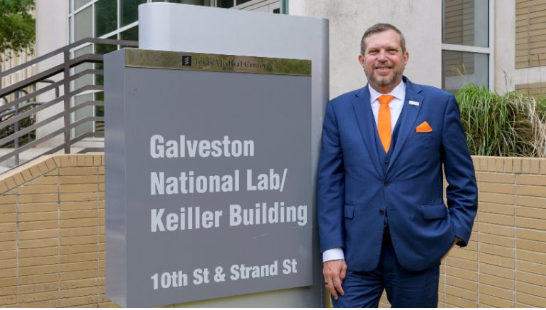 Dr. Olinger is shown standing in front of the Galveston National Lab.