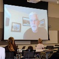 Dr. Ottenbacher speaking on a video in front of guests