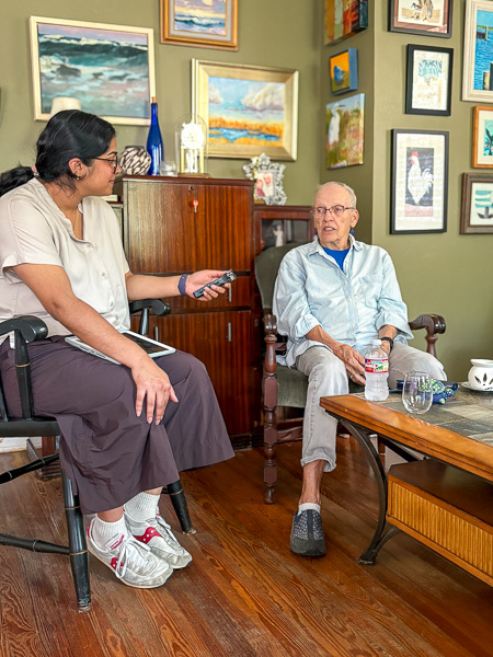A medical student, (Annika Nambiar) interviews an older adult, (Bets Anderson) in her home 