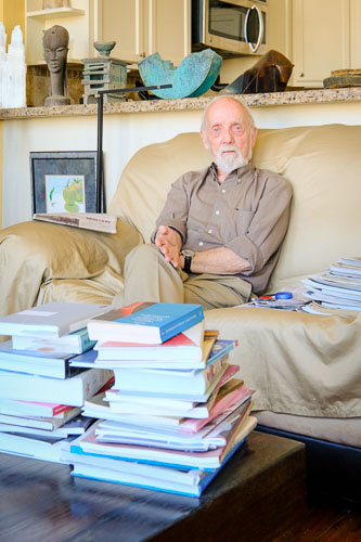 Ulli Budelmann an older man sits behind a stack of books
