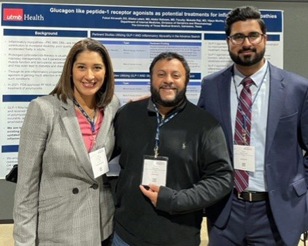three researchers standing in front of a scientific poster at a conference