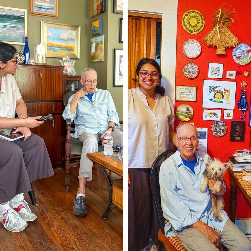 A medical student, (Annika Nambiar) interviews an older adult, (Bets Anderson) in her home holding a recording device, Bets appears thoughtful; Alt: Medical student Annika Nambiar stands with older adult Bets Anderson in her home with her pet dog