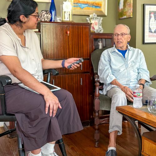 A medical student, (Annika Nambiar) interviews an older adult, (Bets Anderson) in her home