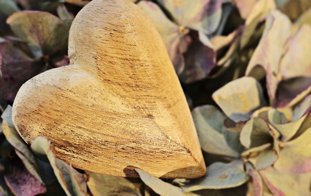 carved wooden hearts among leaves and petals