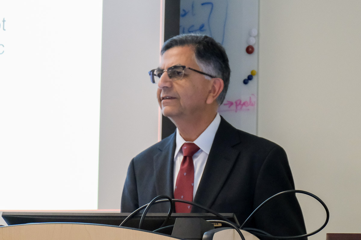 a man wearing a suit giving a presentation in a classroom setting