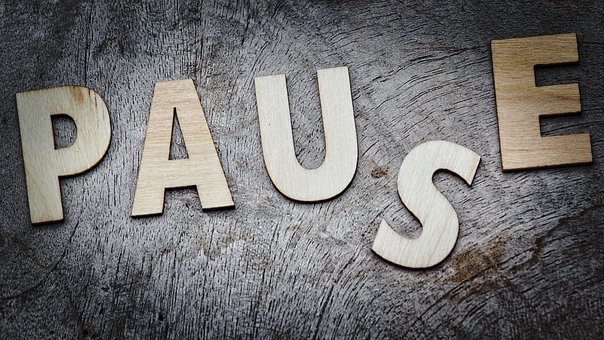 text wooden letters spelling out "PAUSE"