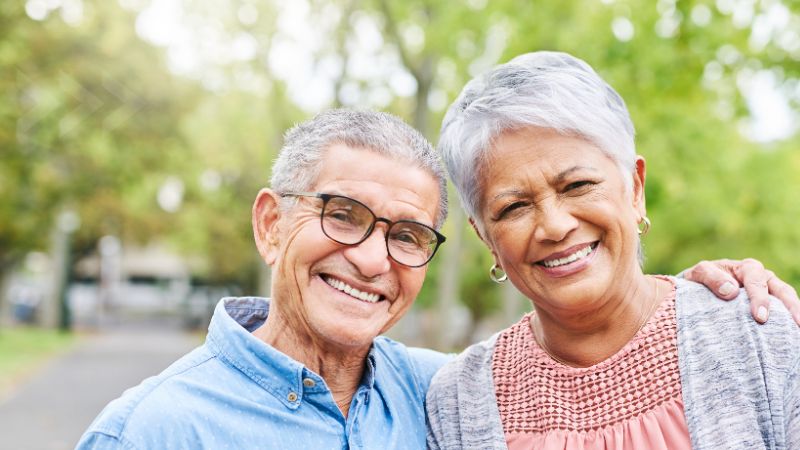 photo of older man and woman outdoors smiling