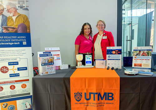 two women stand at a booth during a technology conference