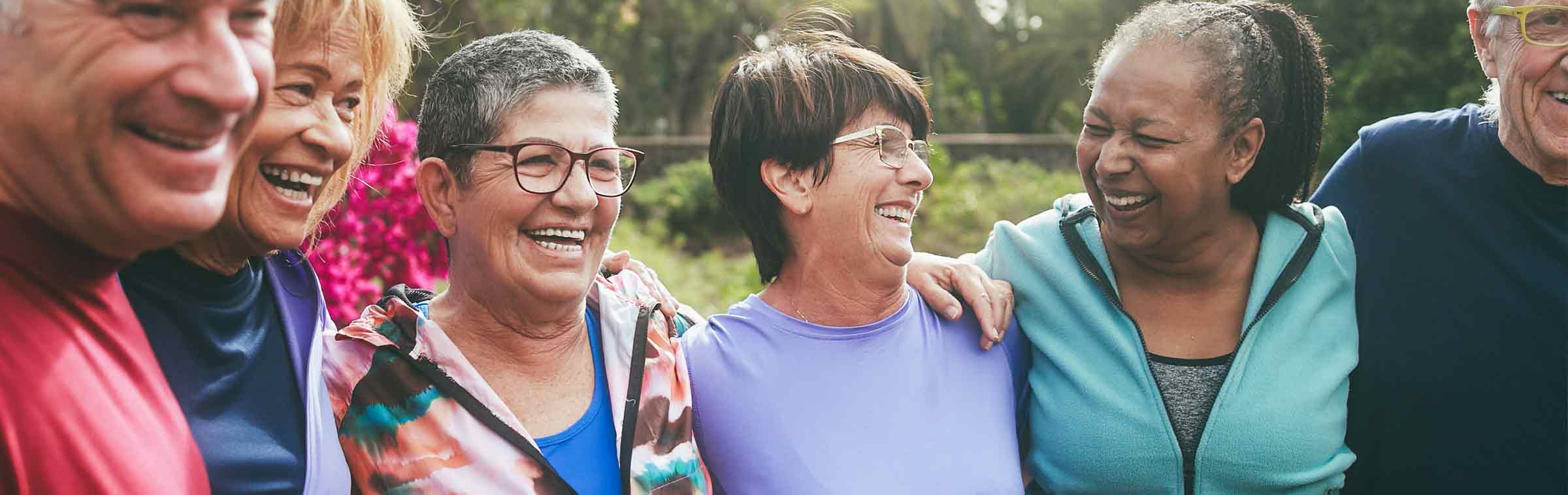 diverse group of older adults wearing athletic clothing together outdoors