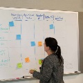 dark haired woman at white board