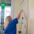blonde woman in scrubs at white board