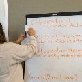 Woman writes on board