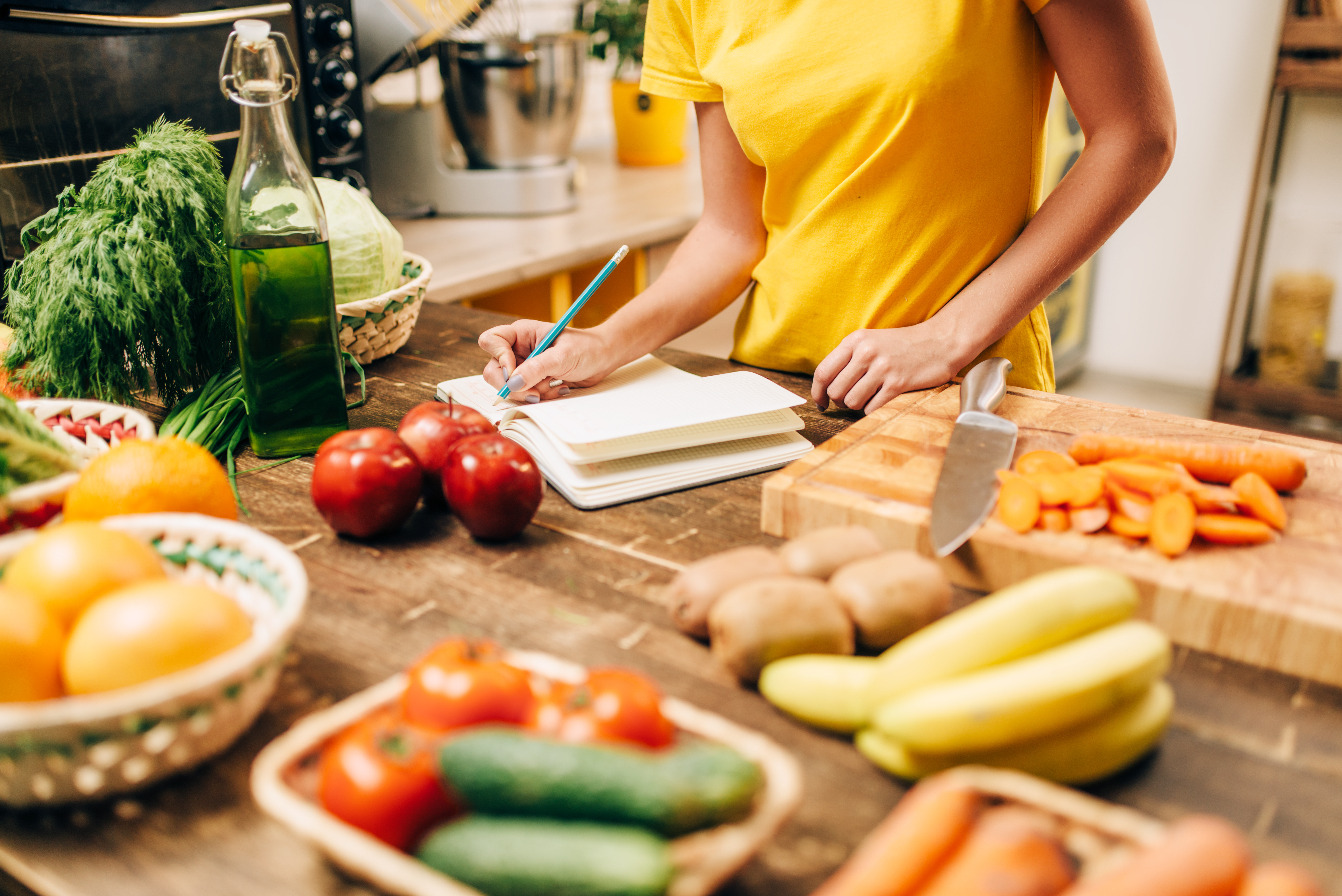 Woman standing in front of a kitchen counter with fruits and vegetables