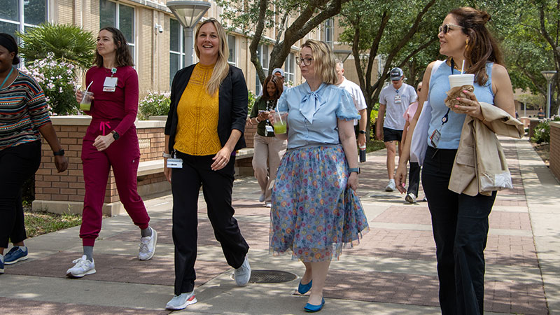 A group of UTMB employees walk together in front of the Galveston National Laboratory during Wellness Wednesday