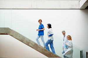 A group of health care employees walk up the stairs