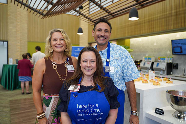 Julie Griffith, Danica Premirelli, and Craig Kovacevich smile for a posed photo at the August Tour de Blue Zones lunch