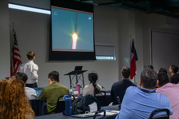 Students in Principles of Aerospace Medicine watch a launch event on TV