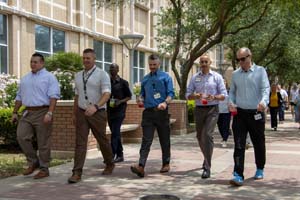 IMG_3962_1 A group of men walking in front of the Galveston National Lab
